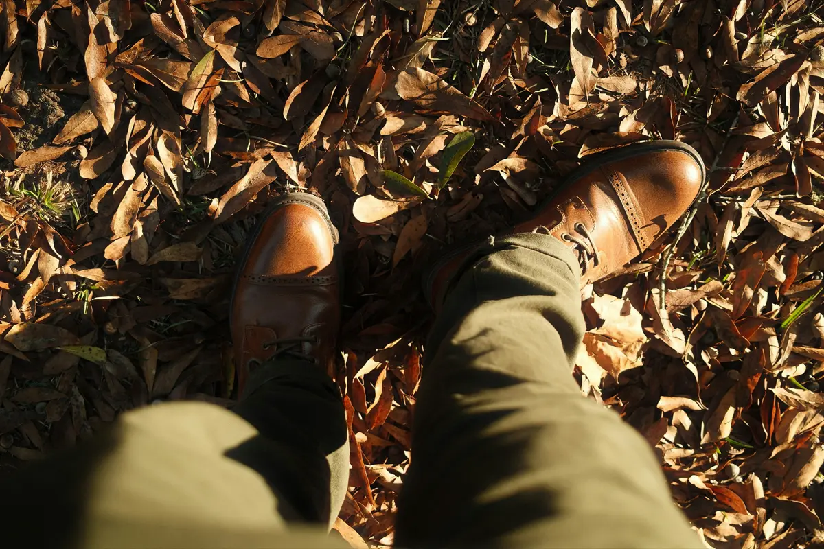Pantalon chino vert olive porté avec des chaussures en cuir marron