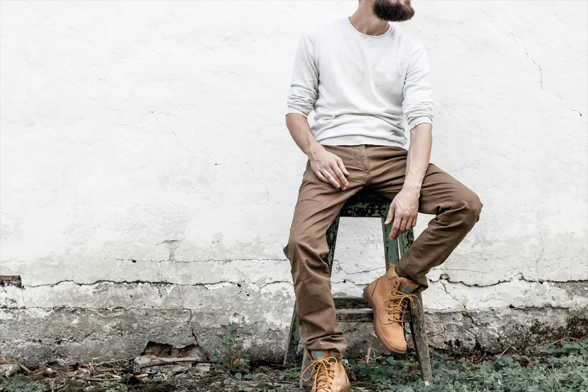 Homme assis portant un chino marron avec des bottines en cuir