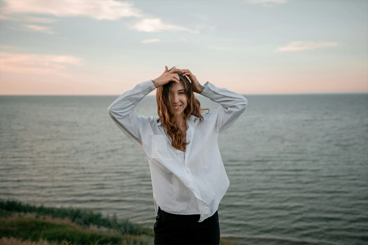 Femme en chemise blanche ample au bord de la mer