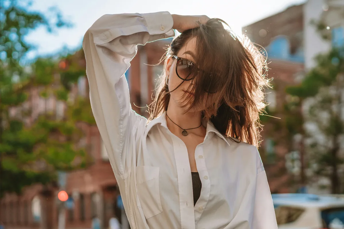 Femme portant une chemise blanche ouverte sur un top noir