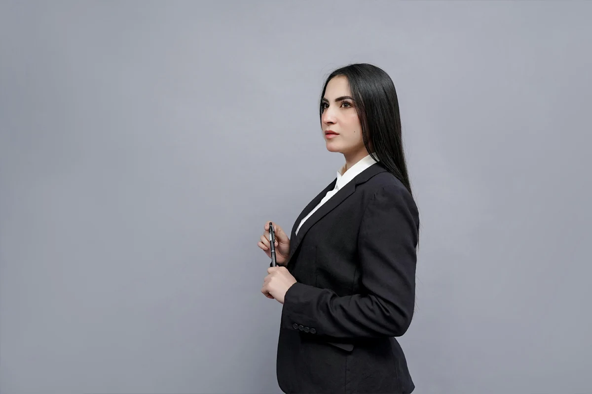 Femme portant un tailleur noir et une chemise blanche pour une tenue de bureau
